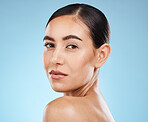 Portrait, shoulder and skincare with a model woman in studio on a blue background for natural beauty. Face, skin and cosmetics with an attractive young female posing to promote a luxury product
