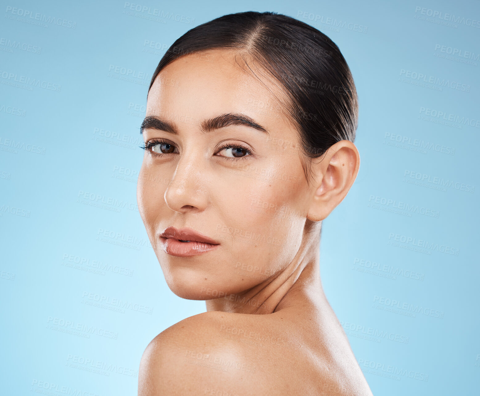 Buy stock photo Portrait, shoulder and skincare with a model woman in studio on a blue background for natural beauty. Face, skin and cosmetics with an attractive young female posing to promote a luxury product