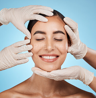 Plastic surgery, beauty and woman in a studio for a skincare, natural and cosmetic facial treatment. Cosmetics, self love and surgeon hands on a female model face for consultation by blue background.