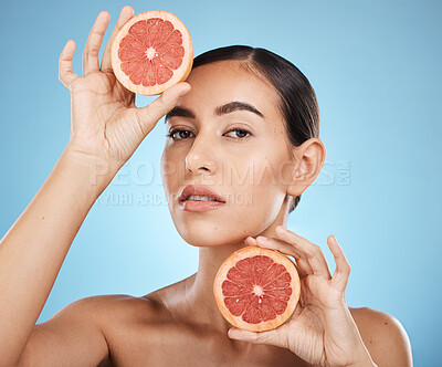 Buy stock photo Face, portrait and skincare of woman with grapefruit in studio isolated on a blue background. Organic cosmetics, food and female model with fruits for nutrition, healthy diet or vitamin c for beauty.