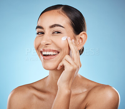Buy stock photo Portrait, beauty and cream with a model woman in studio on a blue background for natural skincare. Face, lotion and cosmetics with an attractive young female posing to promote a skin product