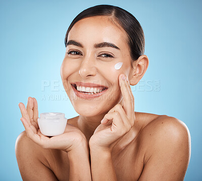 Buy stock photo Face cream, skincare portrait and woman with product in studio isolated on a blue background. Cosmetics, dermatology and happy female model with lotion, creme or moisturizer for beauty and wellness.
