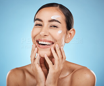 Buy stock photo Portrait, hands and cream with a woman in studio to apply treatment on a blue background for beauty. Face, skincare and lotion with an attractive young female posing to promote a luxury product