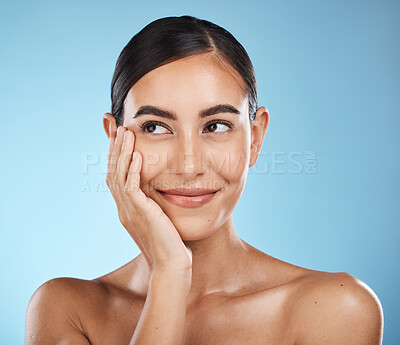 Buy stock photo Woman is thinking, face and happy with beauty, natural cosmetics and glow isolated against blue background. Clean, cosmetic care and hand with facial, makeup and healthy skin with skincare in studio