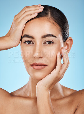 Buy stock photo Portrait, beauty and hands with a model woman in studio on a blue background for natural skincare. Face, skin and cosmetics with an attractive young female posing to promote a luxury product