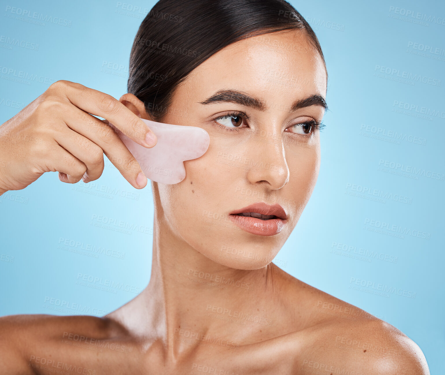 Buy stock photo Skin care, face massage and beauty woman with gua sha for dermatology, cosmetics and wellness. Aesthetic model person with facial scraping stone spa product to relax and glow on blue background