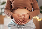 Heart hands on belly, pregnant mother and closeup of happy black woman alone in Africa living room. Excited future parent, holding healthy abdomen at home and natural beauty in pregnancy care