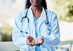 Healthcare, open hands and woman doctor working in a hospital for volunteer, support or charity. Help, stethoscope and African female medical worker with a giving hand gesture in a medicare clinic.