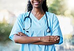 Healthcare, crossed arms and African female doctor with stethoscope standing in a garden in nature. Happy, smile and professional black woman medical worker in a medicare hospital after consultation.