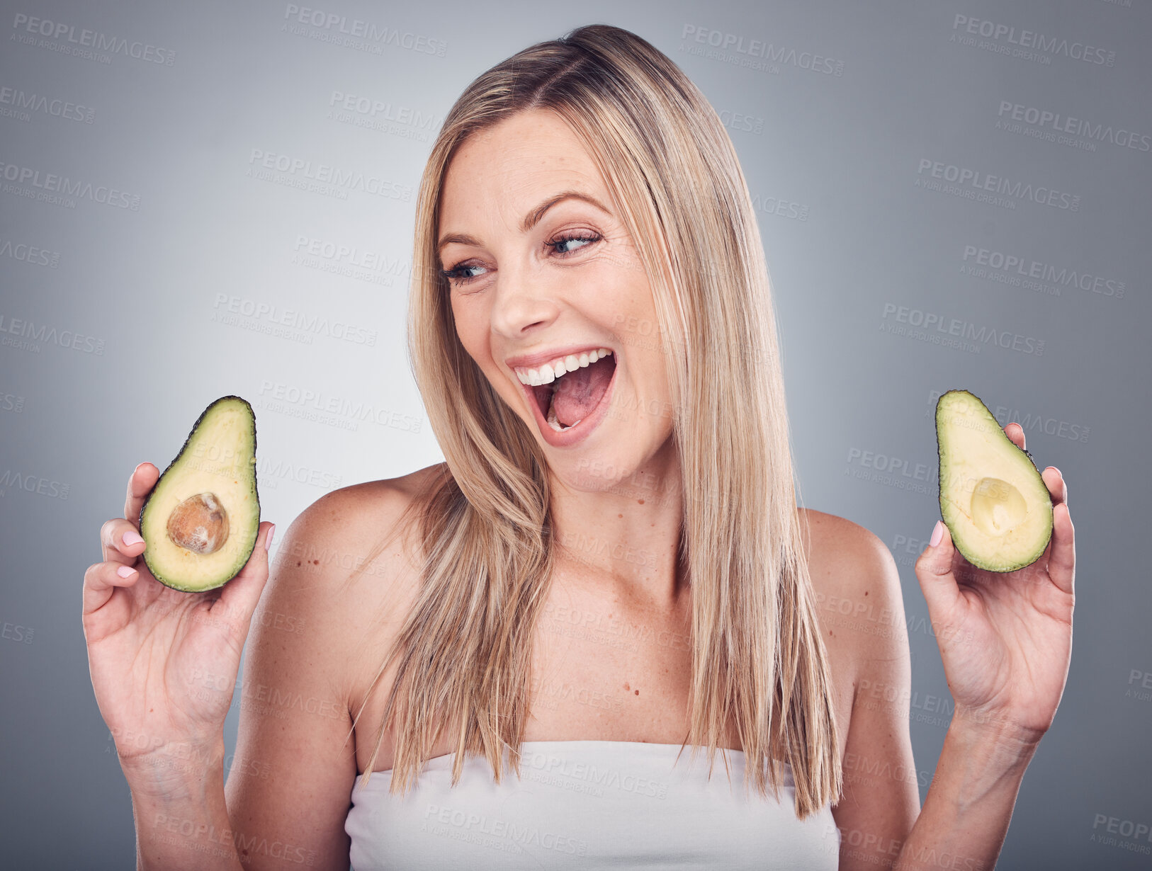 Buy stock photo Beauty, avocado and skin or hair care of a woman in studio with natural cosmetics and shampoo for shine. Face of aesthetic model excited on a grey background for hairdresser or sustainable product