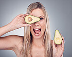 Beauty, avocado and skin care woman portrait in studio with natural glow and cosmetic shine. Comic face of aesthetic model excited on grey background for sustainable food or hair product benefits