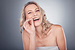 Portrait, hair and mustache with a model woman in studio on a gray background laughing while having fun. Face, beauty and skincare with a carefree young female posing to promote humor or haircare