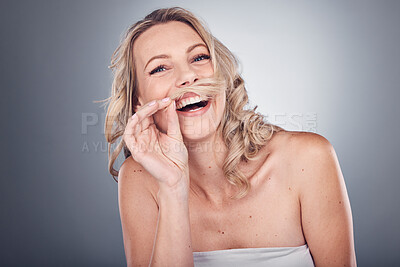 Buy stock photo Portrait, hair and mustache with a model woman in studio on a gray background laughing while having fun. Face, beauty and skincare with a carefree young female posing to promote humor or haircare