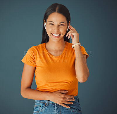 Buy stock photo Woman, happy portrait and listening to music online while streaming on a studio background. Smile of a young gen z person with wireless earphones for funny podcast, radio or audio to relax on blue