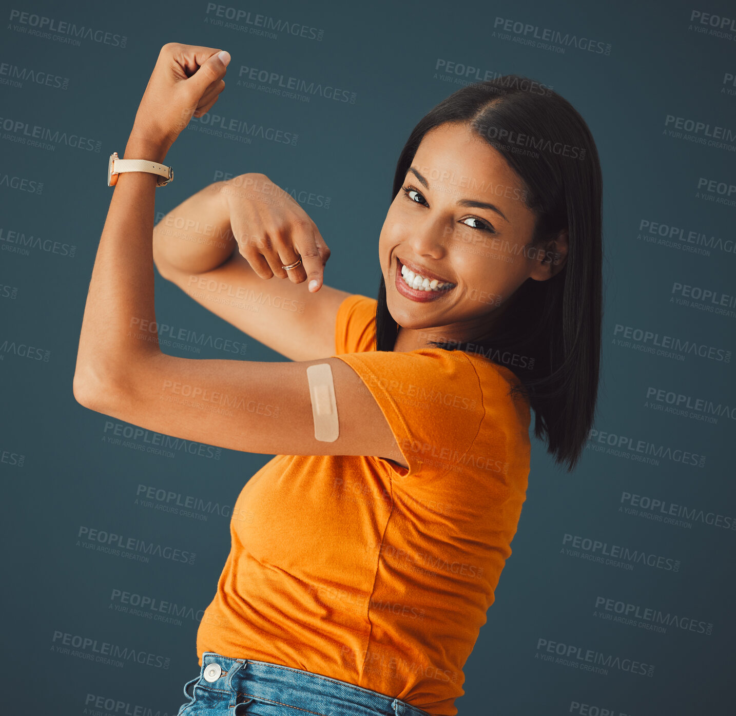 Buy stock photo Vaccine, plaster and portrait of a woman in a studio with a strength gesture after being vaccinated. Happy, smile and proud female model with a vaccination band aid isolated by a dark blue background