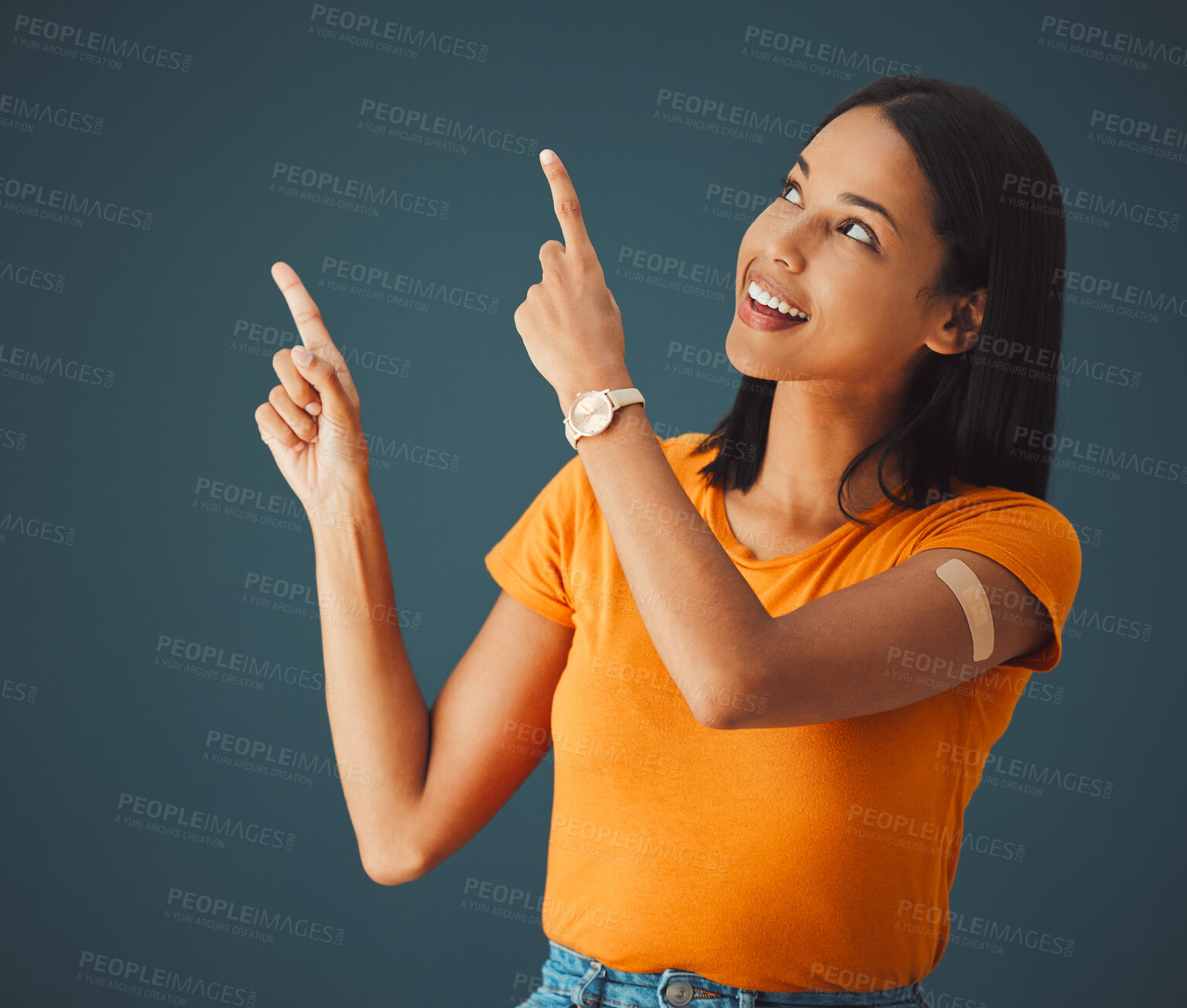 Buy stock photo Woman, hands and pointing in studio for covid, vaccine and healthcare with mockup, space and grey background. Health, girl and model with plaster for corona, shot and immunity or isolated copy space