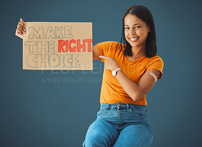 Buy stock photo Black woman, portrait and pointing at protest poster, stop covid or vaccine opinion in healthcare. Happy gen z girl, billboard or wellness choice with plaster, cardboard sign and safety by blue wall