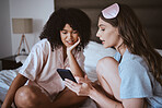 Cellphone, sleepover and women in bed talking, bonding and networking on social media, mobile app or internet. Fun, technology and best friends browsing on website with phone in room at home