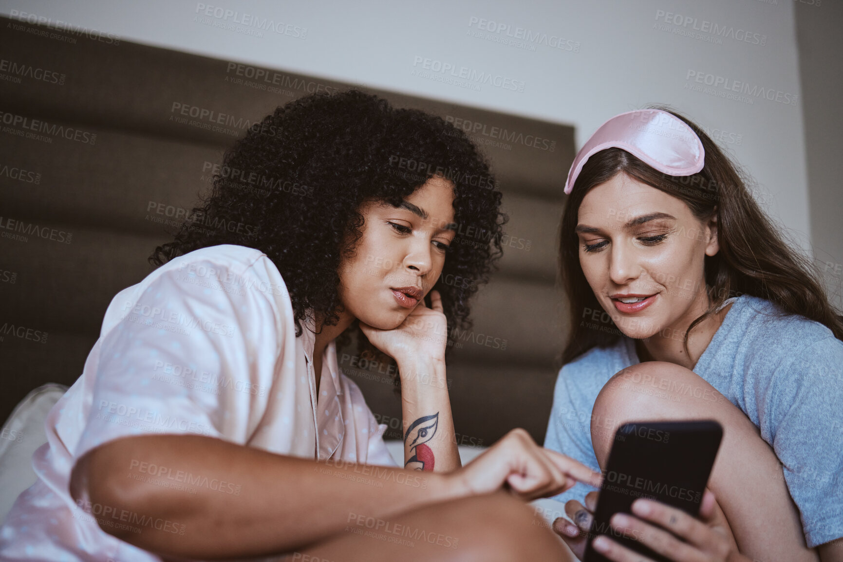 Buy stock photo Phone, sleepover and friends in bed talking, bonding and networking on social media, mobile app or internet. Fun, technology and women browsing on a website with a cellphone in a bedroom at home.