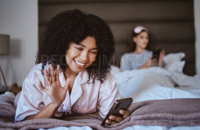 Buy stock photo Video call, phone and wave with black woman at sleepover for communication, internet and contact. Happy, relax and smile with girl and friends in bedroom with technology, digital and social media