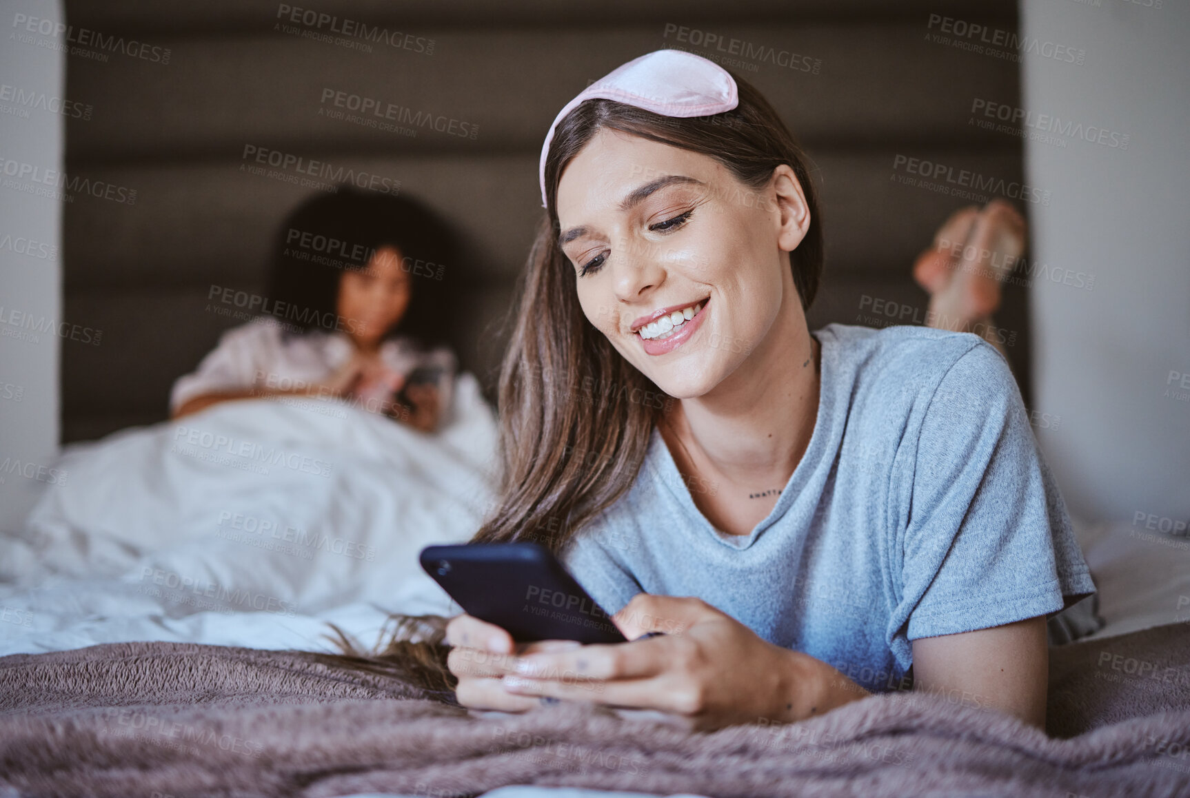 Buy stock photo Phone, bedroom and woman sleepover with social media, networking and internet search for blog tips. Relax, holiday and happy person or youth on bed typing on mobile chat app, cellphone or smartphone