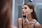 Cosmetic application in mirror, woman with makeup brush and getting ready at home in Los Angeles. Apply luxury beauty product in reflection, face of gen z model and creative aesthetic on skin