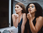 Women, friends and cosmetics at mirror in bathroom for beauty, wellness and makeup in night together. Black woman, girl and model with lipstick, dark aesthetic and support for cosmetic application
