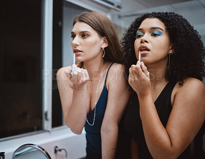 Buy stock photo Women, friends and cosmetics at mirror in bathroom for beauty, wellness and makeup in night together. Black woman, girl and model with lipstick, dark aesthetic and support for cosmetic at party