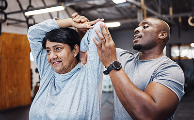 Buy stock photo Personal trainer, coach and senior woman stretching arms in gym with black man for flexibility. Sports, training and elderly female with male trainer helping with workout and exercise for health.