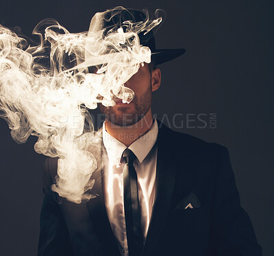 Buy stock photo Mafia, criminal and man with smoke in a suit for fashion isolated on a dark background in a studio. Sexy, vintage and businessman looking stylish, gangster and rich while smoking on a backdrop