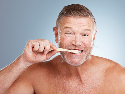 Buy stock photo Portrait, mouth or old man brushing teeth with dental toothpaste for healthy oral hygiene grooming in studio. Eco friendly, funny or senior person cleaning with a natural bamboo wood toothbrush 