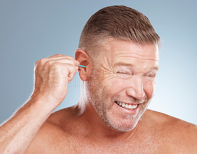 Buy stock photo Man, ear bud and grooming in skincare, cosmetics or hygiene products against a gray studio background. Male person cleaning ears for body care or self love in clean beauty, health and wellness