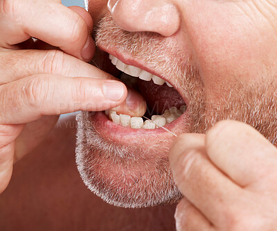 Dental, hands and mouth of man with floss in studio isolated on background for health. Oral hygiene, wellness and face of senior male model with thread or string for flossing, cleaning or teeth care.