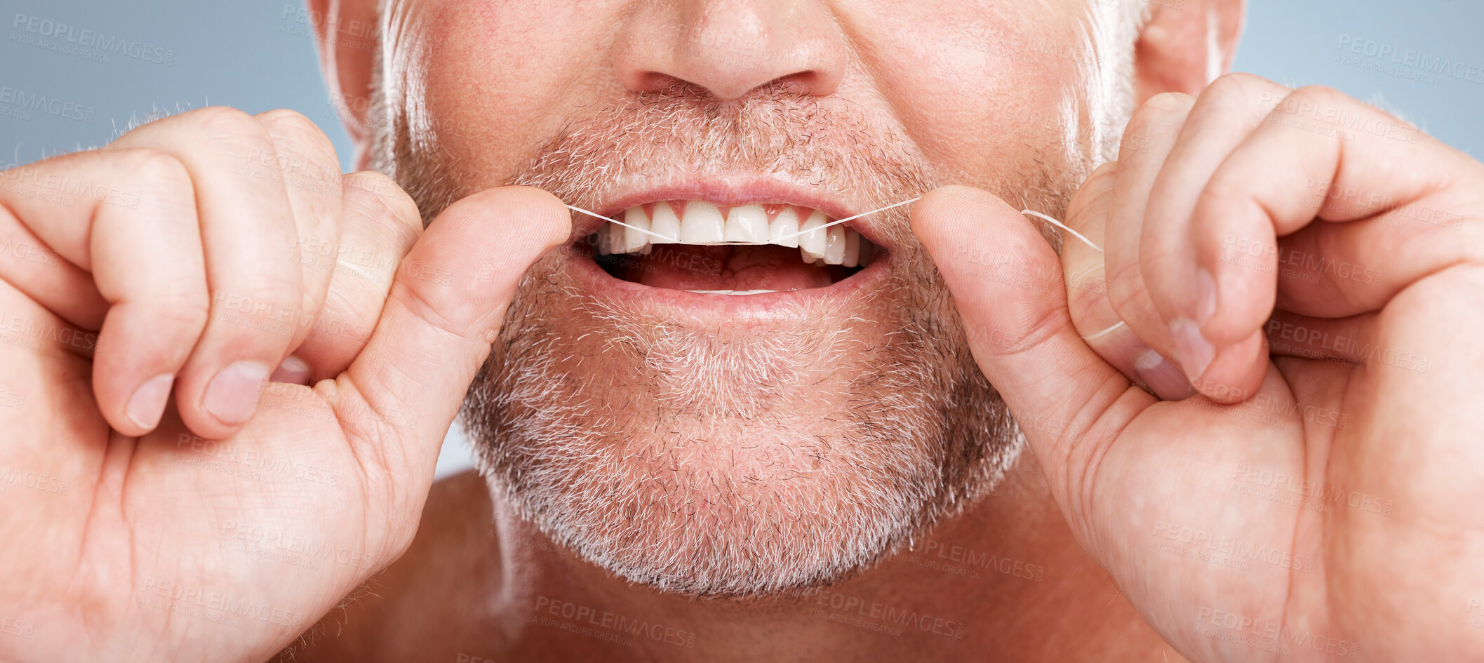 Buy stock photo Closeup, floss and man with dental health, cleaning teeth and fresh breath against grey studio background. Male, gentleman and string for oral hygiene, wellness and morning routine for mouth grooming
