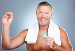 Dental, floss and portrait of man with product in studio isolated on a gray background. Oral hygiene, health and mature male model with container with thread for flossing, cleaning and teeth care.