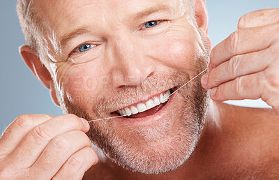 Face portrait, dental and with man with floss in studio isolated on a gray background for health. Oral hygiene, wellness and happy senior male model with thread for flossing, cleaning or teeth care.