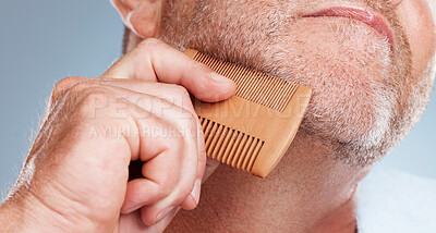 Buy stock photo Grooming, hair care and man brush beard for wellness, healthy skin and hygiene on blue background. Salon aesthetic, cleaning and face zoom of male with barber comb for facial, skincare and beauty