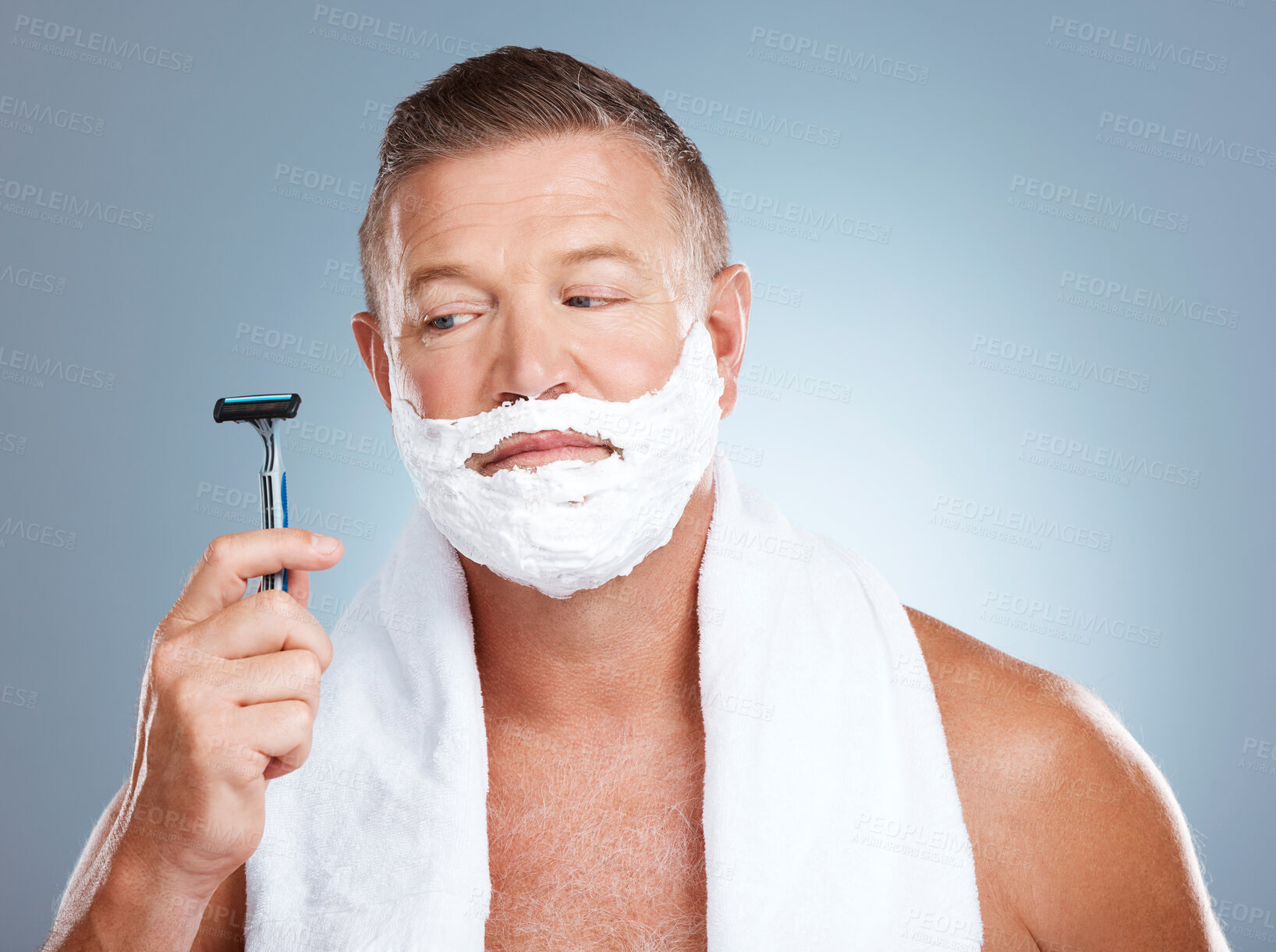 Buy stock photo Skincare, razor and old man shaving in studio with foam, beauty or grooming on grey background. Face, doubt and mature male model relax for luxury, hair removal and facial, skin and product isolated