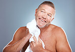 Happy, old man and skincare in studio with towel for face, cleaning or grooming on grey background. Facial, mature and male model relax for luxury, skin or beauty, wrinkles or treatment and isolated