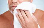 Closeup, old man and towel to dry face, clean and hygiene for healthy skin, beard and guy on grey studio background. Zoom, senior citizen and mature male with cosmetics cloth, washing and skincare