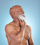 Water splash, wellness and beauty with black man and shower for skincare, hygiene or dermatology. Self care, spa and facial with senior model in blue background studio for health, luxury or hydration