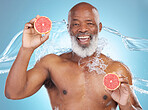 Black man, portrait smile and grapefruit for skincare nutrition, vitamin C or hydration against a blue studio background. Happy African American male smiling and holding fruit for health and wellness