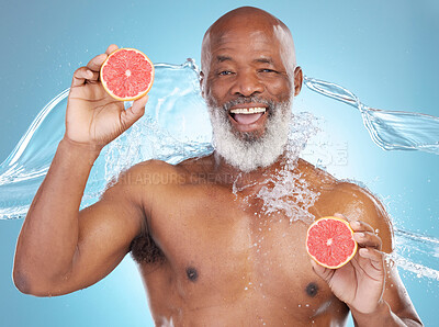 Buy stock photo Black man, portrait smile and grapefruit for skincare nutrition, vitamin C or hydration against a blue studio background. Happy African American male smiling and holding fruit for health and wellness