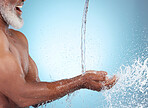 Hands in water splash, mockup and black man with smile health and hygiene isolated on blue background. Fresh, cleaning in shower and male skincare, dermatology and product placement profile in studio