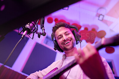 Buy stock photo Happy man, musician or guitar in neon studio, recording production or performance for radio, label or low angle concert. Guitarist, artist or singer playing strings instrument on headphones practice