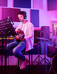 Musician, headphones or guitar in neon studio, recording production or performance on radio mic, label or band concert. Guitarist, artist or man playing on strings instrument in night light practice