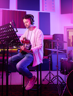 Buy stock photo Musician, headphones or guitar in neon studio, recording production or performance on radio mic, label or band concert. Guitarist, artist or man playing on strings instrument in night light practice