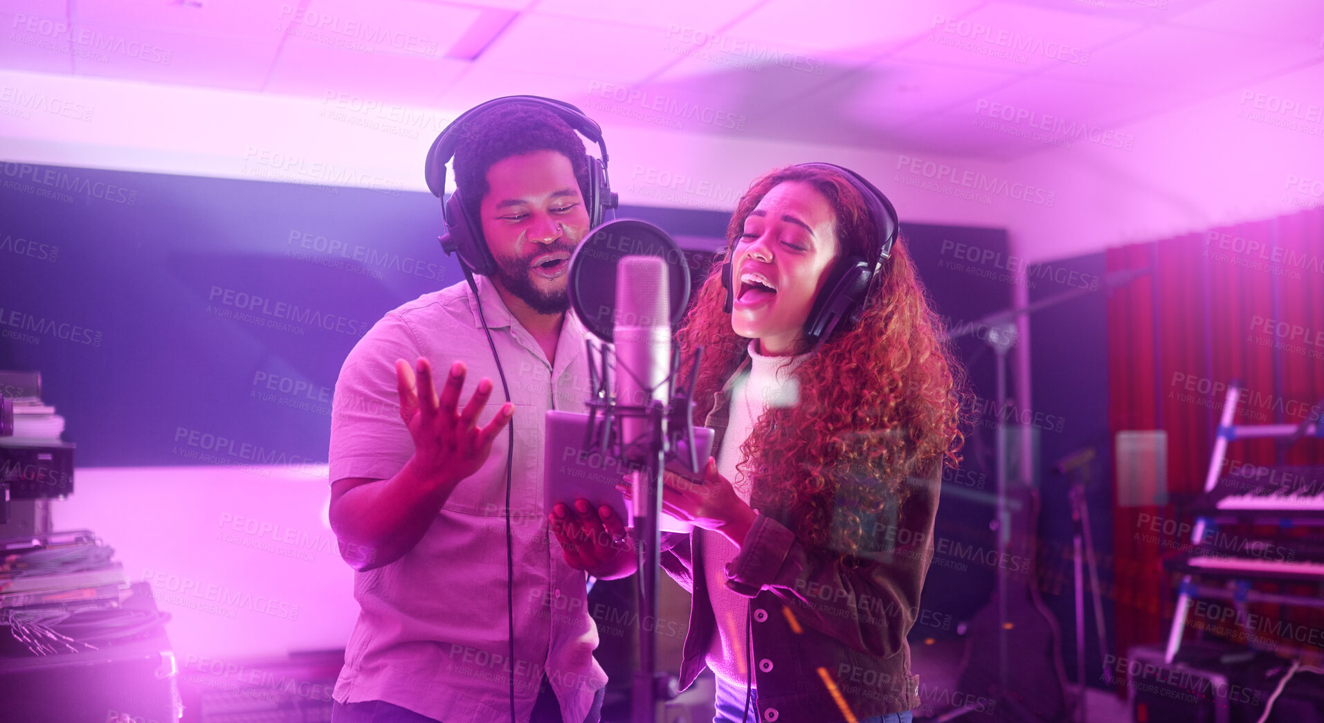 Buy stock photo Technology, singer or musicians on neon studio microphone or music lyrics app in night recording. Singing people, collaboration or artists on tablet production, voice media or light sound performance