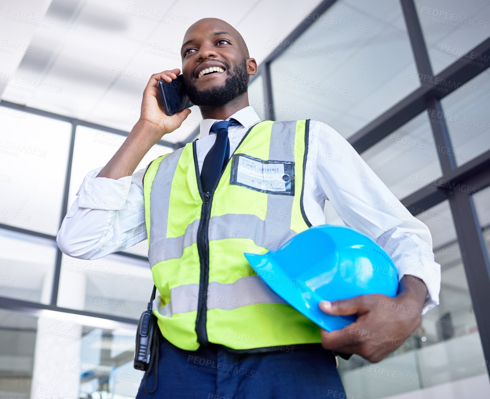 Buy stock photo Black man, construction worker or phone call in building planning, networking or industrial property design in low angle. Smile, happy or engineering architect with mobile technology, helmet or ideas