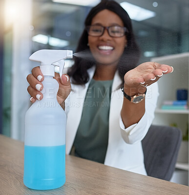 Buy stock photo Hand, covid and sanitizer with a business black woman in her office, sitting at a desk with her spray bottle. Health, safety and cleaning with a female employee using chemical disinfectant at work